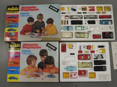 two boxes of assorted toys sitting on a table