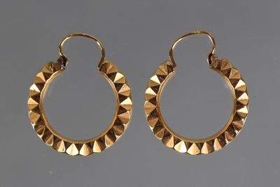 a pair of gold hoop earrings with a circular design