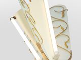a close up of a light fixture with a white and gold design