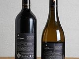 two bottles of wine sitting on top of a wooden table