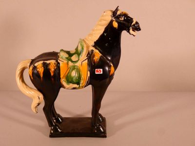 une figurine représentant un cheval, peinte en noir et jaune