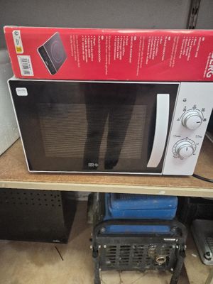 un micro-ondes posé sur une table, avec une boîte dessus