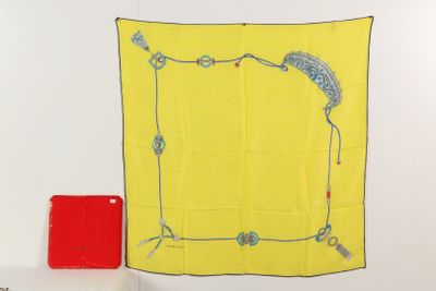 une écharpe jaune accrochée au mur à côté d'une boîte rouge