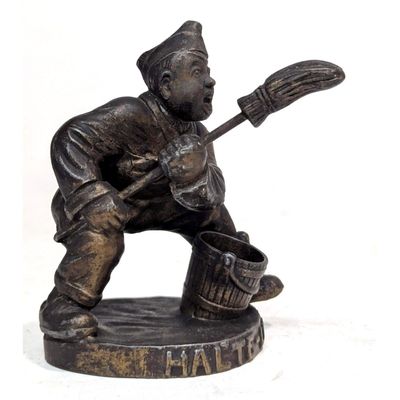 une statue représentant un homme tenant un seau et un balai