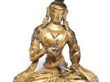 une image représentant une statue en or d'une femme assise sur un lotus