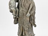une vieille statue représentant un homme tenant un enfant sur un rocher
