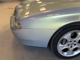 a picture of a silver sports car parked in a garage