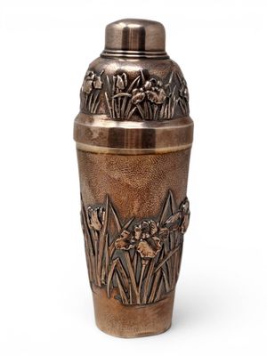 a metal vase with flowers on it on a white background