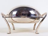 a silver plate on a stand with a mirror in the background