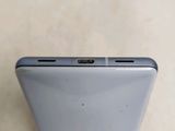the back of a silver cell phone sitting on top of a table