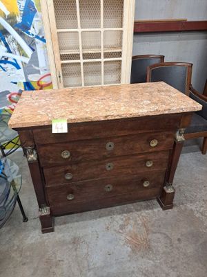 une commode en bois avec un plateau en marbre dans une chambre