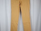 a pair of yellow pants hanging on a hanger in front of a white curtain