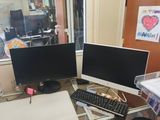 a desk with two computer monitors and a keyboard on it