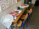 tables and chairs in a room with a bulletin board on the wall