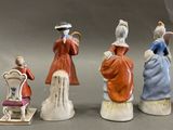 four figurines of people sitting on a chair