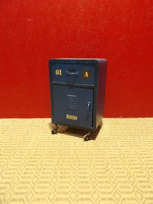 une petite boîte aux lettres bleue posée sur une table