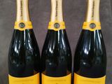 trois bouteilles de champagne posées sur une table