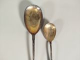 two spoons that are sitting next to each other on a table