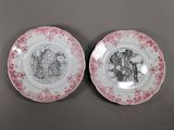 two pink and white plates with black and white designs on them