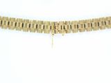 a close up of a gold bracelet with a chain on a white background