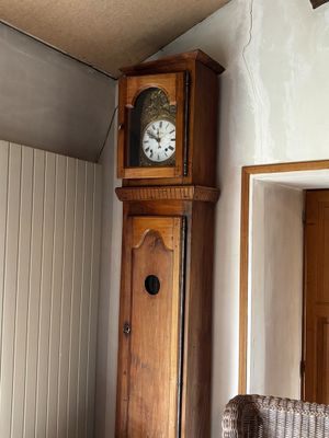 une horloge de parquet qui se trouve dans un coin de la pièce