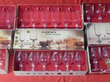 several empty wine glasses in a box on a red table cloth