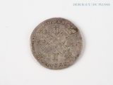an old coin with a cross on it on a white surface