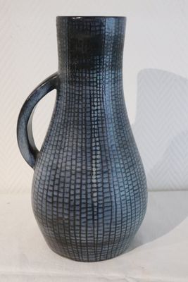 a black vase with a handle sitting on a table