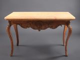 une petite table aux pieds sculptés et au plateau en bois
