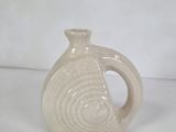 a white vase that has a spiral design on it