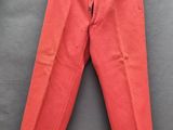 un pantalon rouge suspendu à un cintre accroché au mur