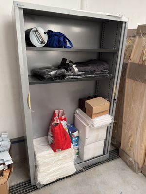 une armoire métallique sur laquelle sont posés de nombreux objets, dans une pièce