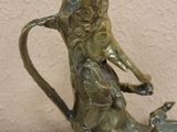 a statue of a cat sitting on top of a teapot