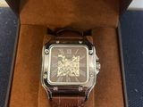 the watch is in a box with a brown strap