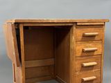 un vieux bureau en bois muni de tiroirs, avec un tiroir en dessous