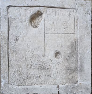 a stone plaque with a picture of a bird on it