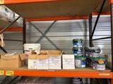 de nombreux cartons de peinture sur une étagère dans un entrepôt