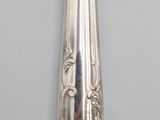 a silver spoon with a silver handle on a white surface