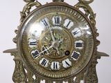 a gold clock with roman numerals on the face