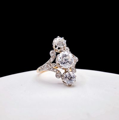 un gros plan d'une bague en diamant posée sur une assiette blanche