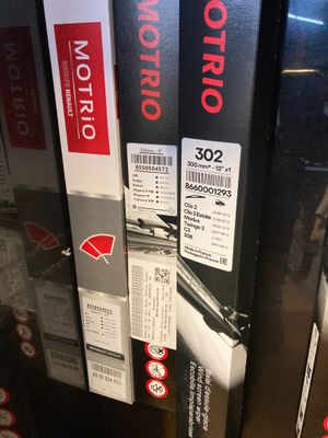 Deux bidons d'huile moteur sont empilés sur une étagère dans un magasin.