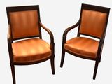 deux chaises en bois avec des assises rembourrées orange sur fond blanc