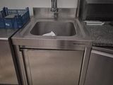 a stainless steel sink in the corner of a kitchen