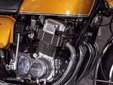a yellow motorcycle parked in a garage with a white wall in the background