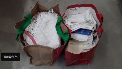 two bags of clothing sitting on the floor next to each other