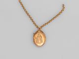 un collier en or avec une pièce de monnaie sur une chaîne