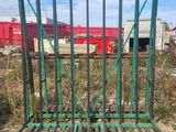 a close up of a green gate with a train in the background