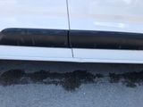 a white car with black trims parked on the side of the road