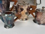 four different types of silver teapots on a table