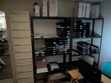 a room with a desk, shelves, and a computer on it
